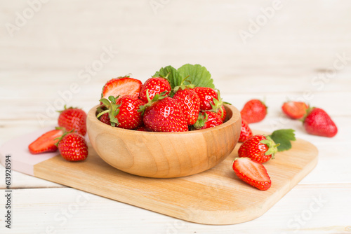 Fresh strawberries in bowl on wooden table