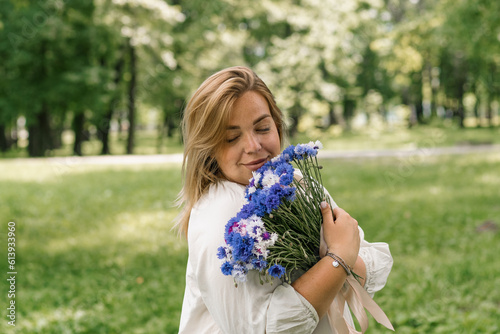 portrait of a beautiful young pregnant woman with a bouquet of flowers in her hands smiling and rejoicing at the presented bouquet