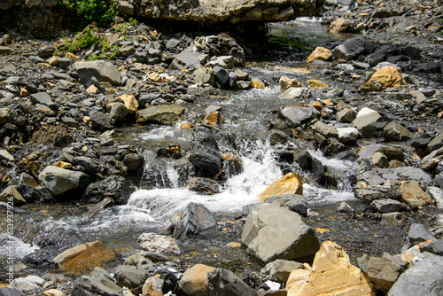 Water flowing over river rocks near mountains in Nathia Gali, Abbottabad, Pakistan. photo