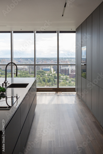 dark minimalistic design of a trendy chic studio apartment with panoramic windows on a high floor overlooking the city