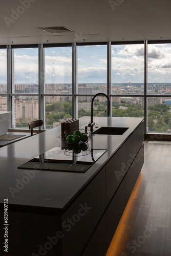 dark minimalistic design of a trendy chic studio apartment with panoramic windows on a high floor overlooking the city