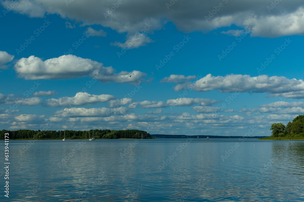 Landscape, view of the lake and the shore, green trees and water surface Landscape, view of the lake and the shore, green trees and water surface