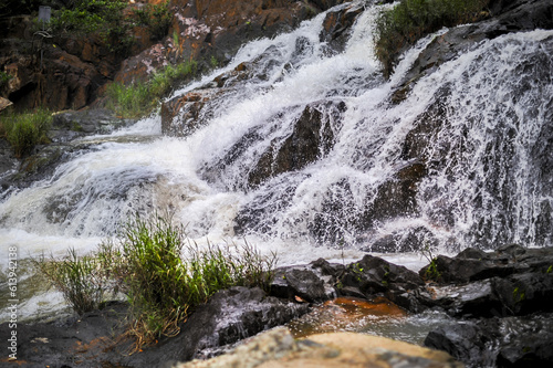 powerful wide waterfall with white foaming water