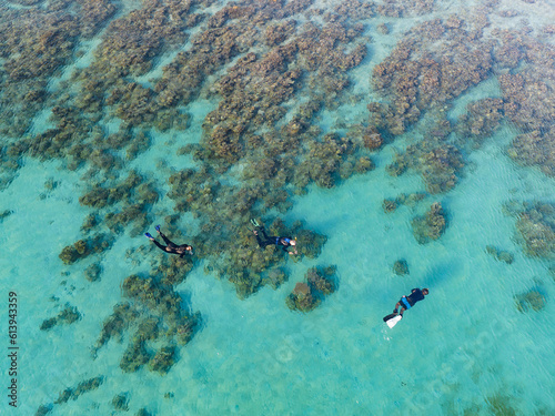 Snorkelers explore a shallow coral reef off the coast of Moyo Island, not far from Lombok, Indonesia. This region is known for its incredible marine biodiversity. photo