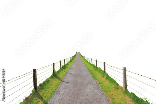 Fototapeta Cutout of an isolated small farm road with fences leading to the wooden gate on