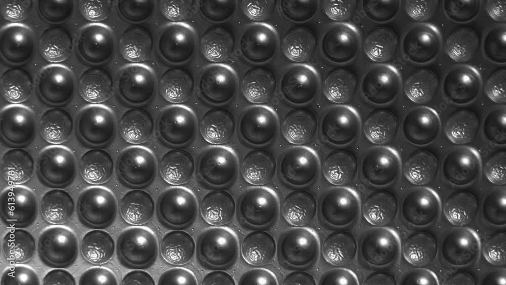 Abstract texture of bubbles covered with aluminum foil. Aluminum heat-reflective foil cover on foamed polymer on the bottom of the ground pad.
