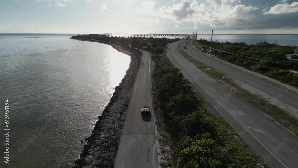 Aerial video view of sports car driving along the coast Aerial video view of sports car driving along the coast
