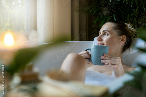 Fototapeta woman relaxing in bath and drink a coffee at home bathroom