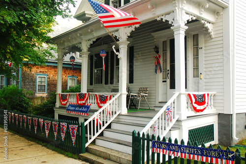 A historic house in New England is decorated with American flags on the Fourth of July Independence day