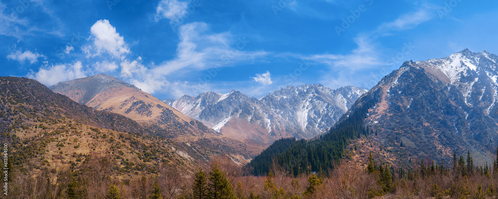 Panorama of mountains and glaciers under blue cloudy sky panoramic