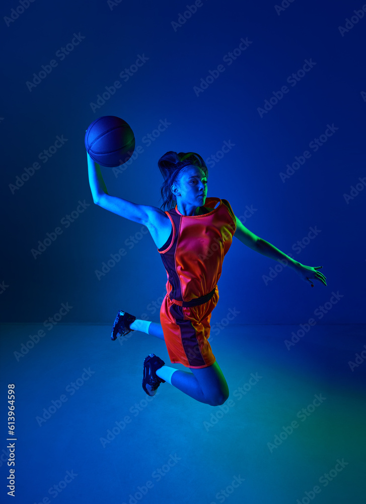 Slam dunk. Top view of young girl, basketball player throwing ball