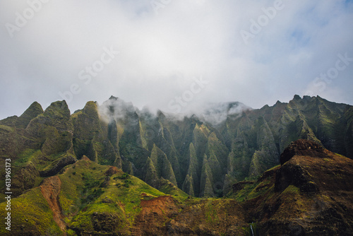 Fog over the mountains of the NaPali Coastline on the island of Kauai, Hawaii on a cloudy day from a sunsets boat cruise