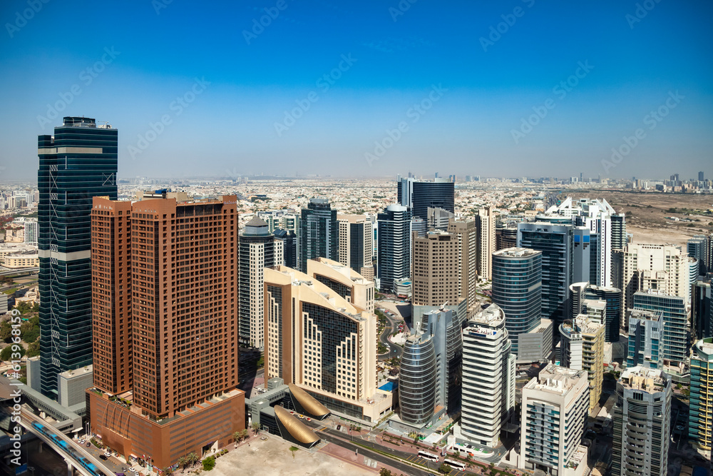 Cityscape district Dubai modern skyscrapers sunny summer day, urban background. Panoramic aerial view of UAE city housing new towers. Construction and modern architecture concept. Copy ad text space