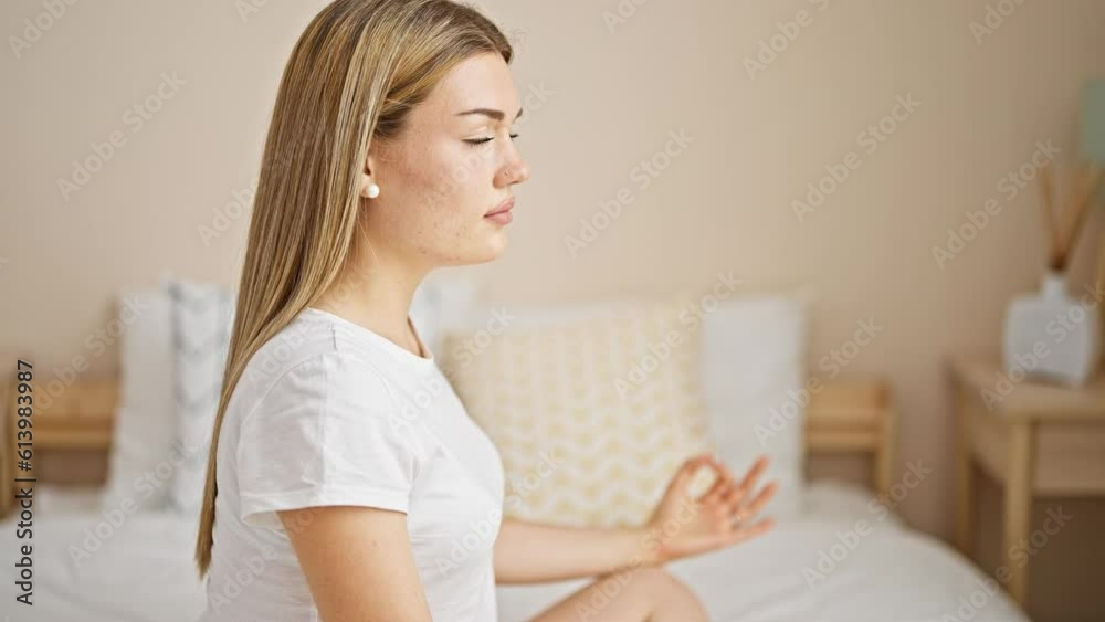 Young blonde woman doing yoga exercise sitting on bed at bedroom Young blonde woman doing yoga exercise sitting on bed at bedroom