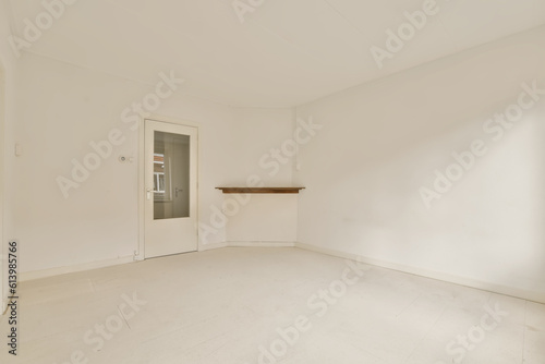 an empty living room with white walls and floor  there is a door leading to the left side of the room