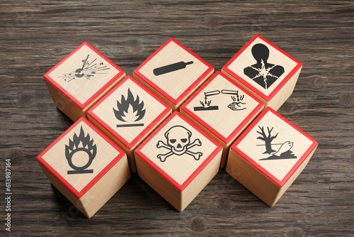 Wooden blocks showing different symbols of chemical hazard warnings on wood table. Illustration of the concept of toxic substances and occupational health