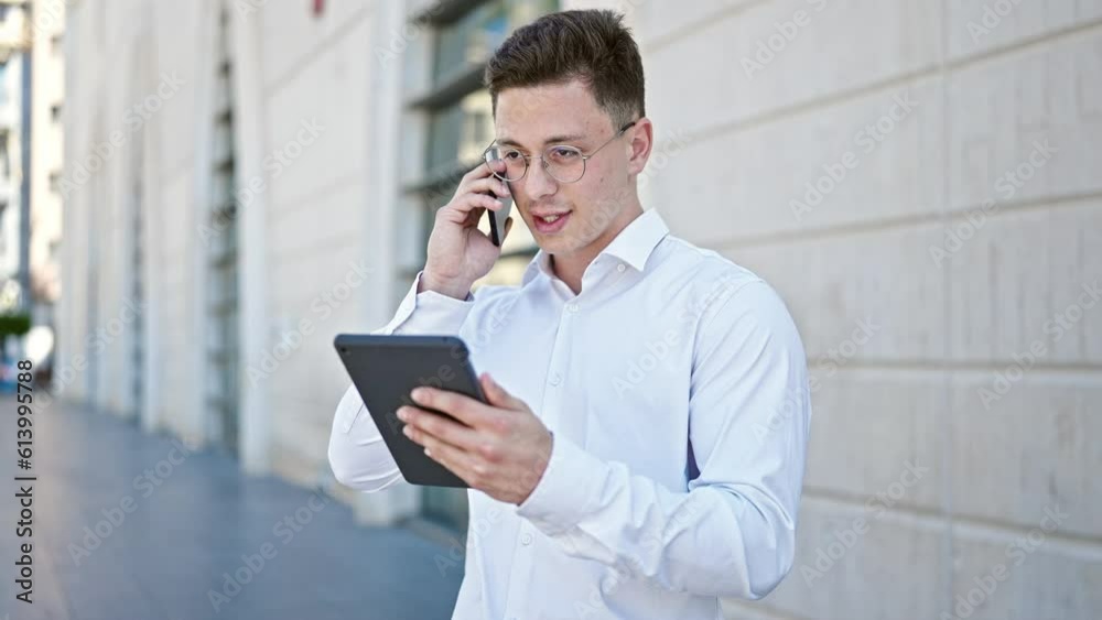 Young hispanic man talking on smartphone using touchpad at street Young hispanic man talking on smartphone using touchpad at street
