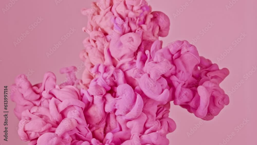 Pink paint drops in pink background in water, beautiful modern soft colors, slow motion Pink paint drops in pink background in water, beautiful modern soft colors, slow motion