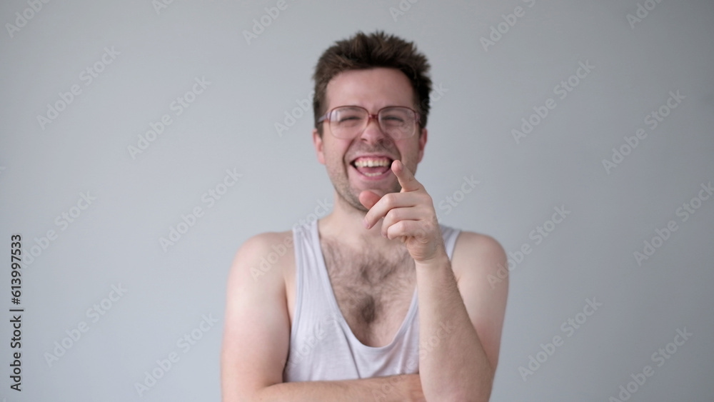 © RealPeopleStudio - A sarcastic man in big glasses mockingly laughs and points his finger at the camera © RealPeopleStudio - A sarcastic man in big glasses mockingly laughs and points his finger at the camera