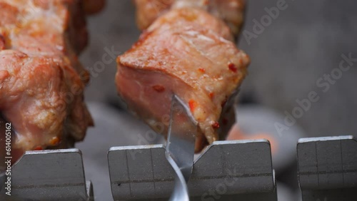 Meat is grilled on a skewer, close up slow motion photo