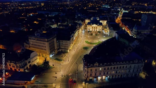 Aerial drone view of Oradea downtown at night, Romania. Crisul Repede river, State Theatre with people coming out, illumination photo