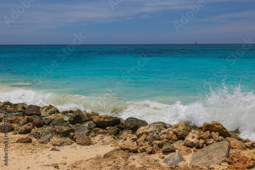 Gorgeous view of turquoise waves Caribbean sea on sandy beach rocky coast of island of Aruba.