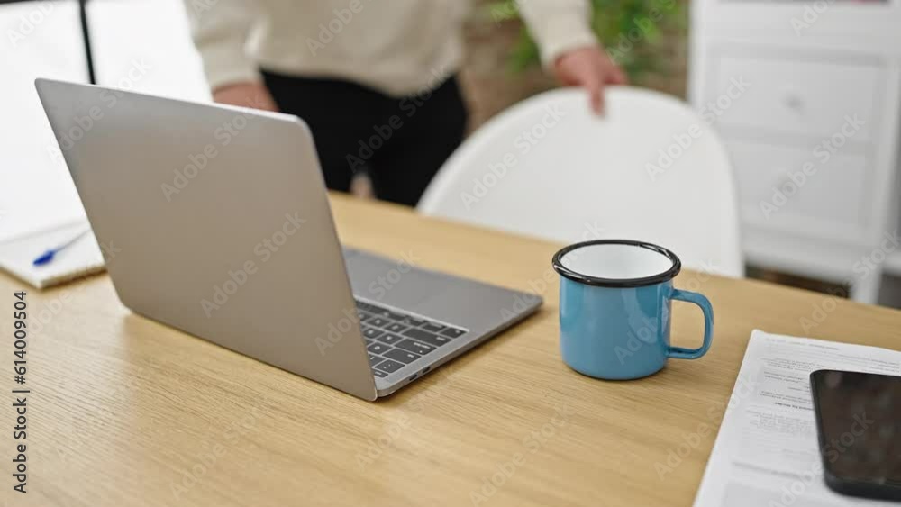 Young caucasian man sitting on table using laptop at dinning room