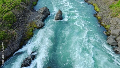 Large river flows through a rocky landscape in Iceland. Clear turquoise glacial water. Beautiful summer nature. photo