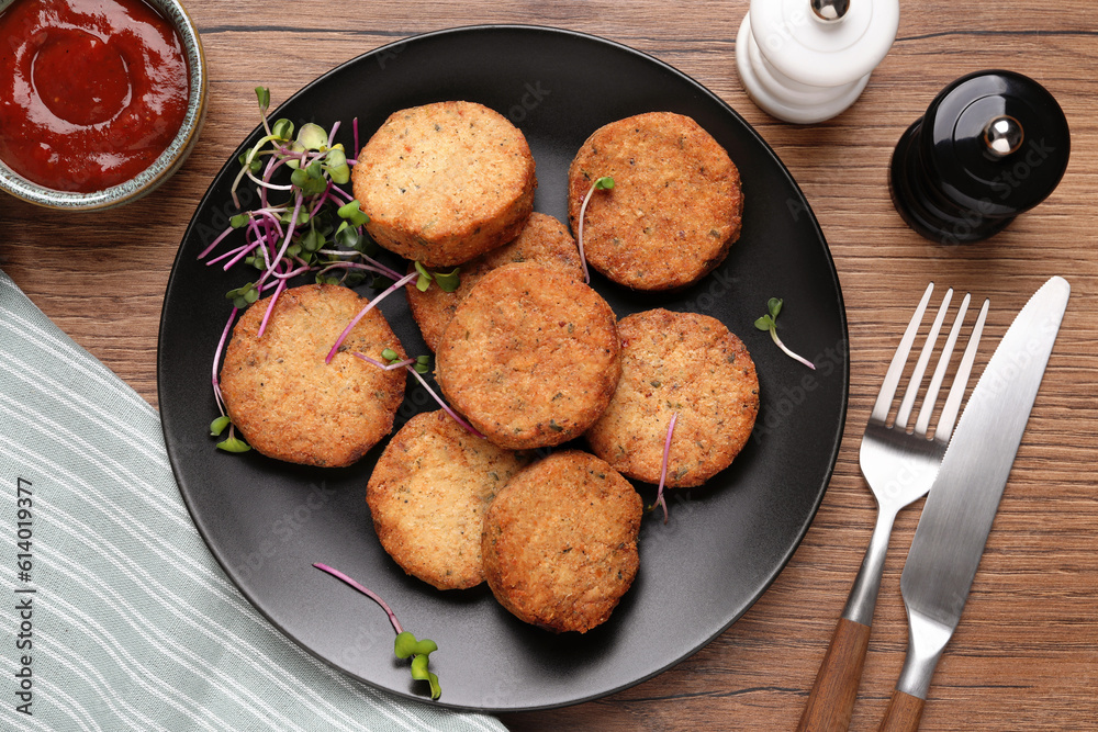 Delicious vegan cutlets served on wooden table, flat lay