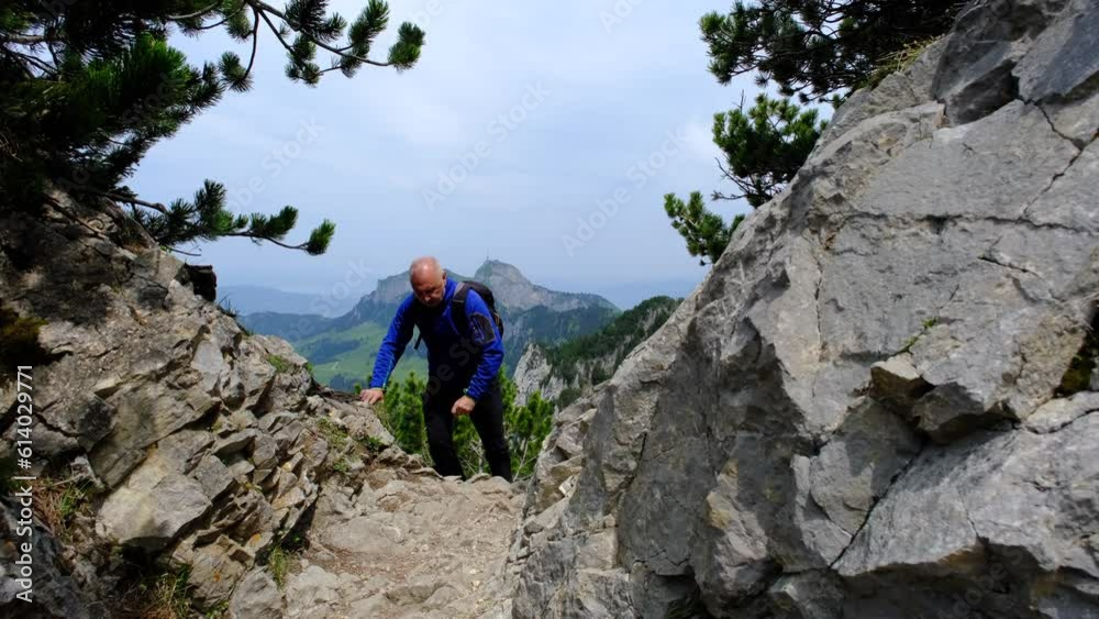 A man is hiking in the mountain with a beautiful mountain in the background. A man is hiking in the mountain with a beautiful mountain in the background.