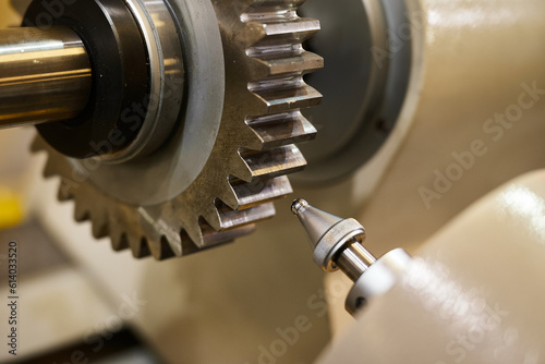 Shiny metal cogwheel and oil snout in production workshop