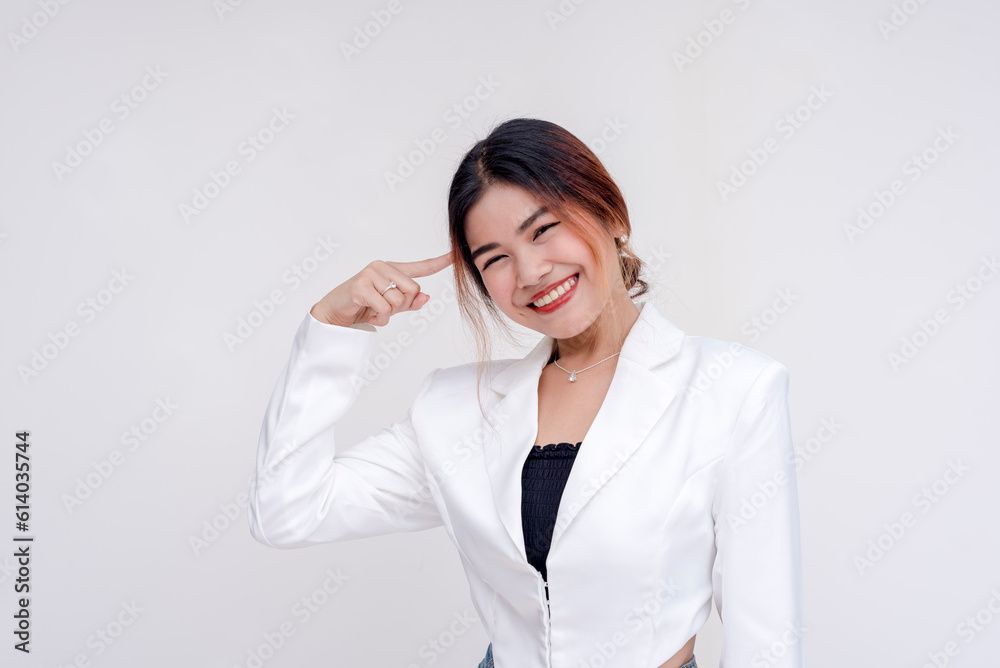 A cheerful young lady pointing to her brain while looking at the camera. Isolated on a white background. A cheerful young lady pointing to her brain while looking at the camera. Isolated on a white background.