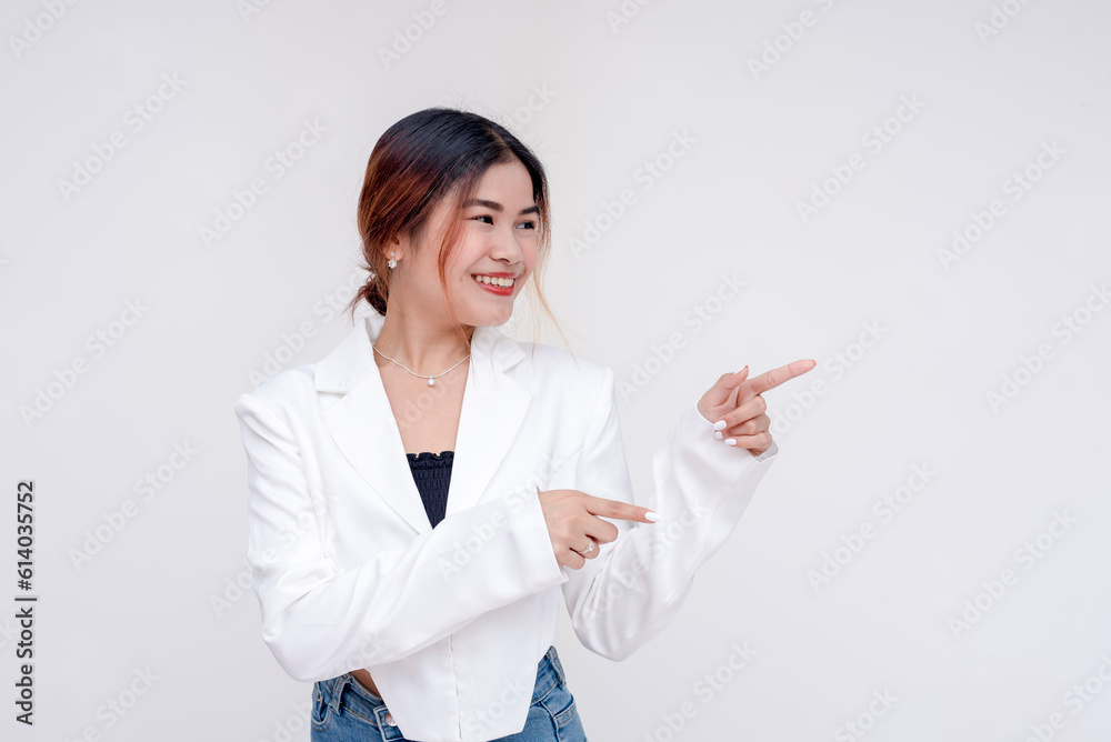 A playful young woman looking sideways while pointing both her fingers to right side. Isolated on a white background. A playful young woman looking sideways while pointing both her fingers to right side. Isolated on a white background.