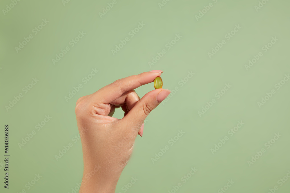 A hand holding a fish oil capsule. Fish oil is one of the most commonly consumed dietary supplements. Rich in omega-3 fatty acids A hand holding a fish oil capsule. Fish oil is one of the most commonly consumed dietary supplements. Rich in omega-3 fatty acids
