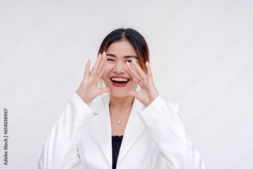 A beaming and joyful young lady yelling with cupped hands while looking at the camera. Isolated on a white background. A beaming and joyful young lady yelling with cupped hands while looking at the camera. Isolated on a white background.