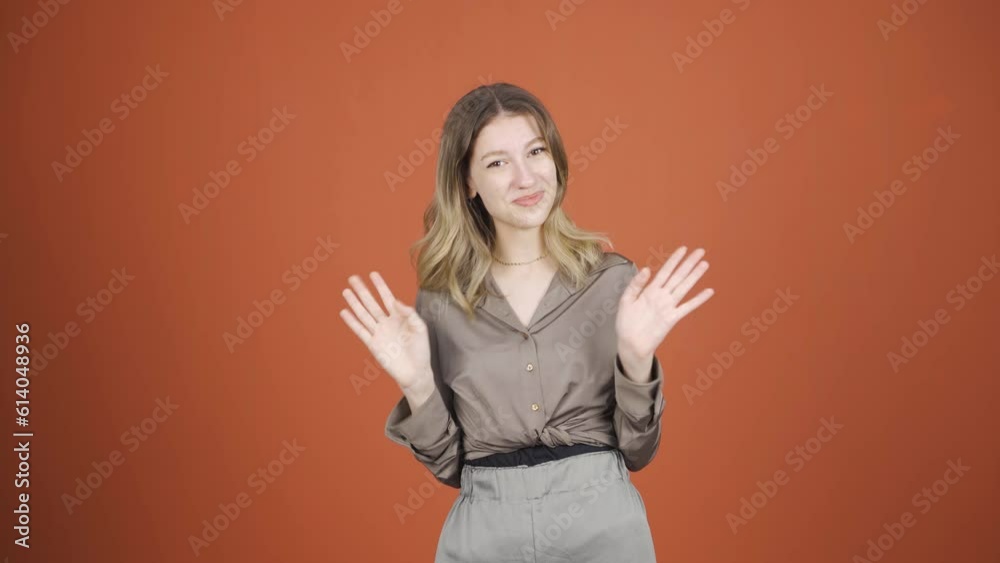 Happy young woman waving at camera. Happy young woman waving at camera.
