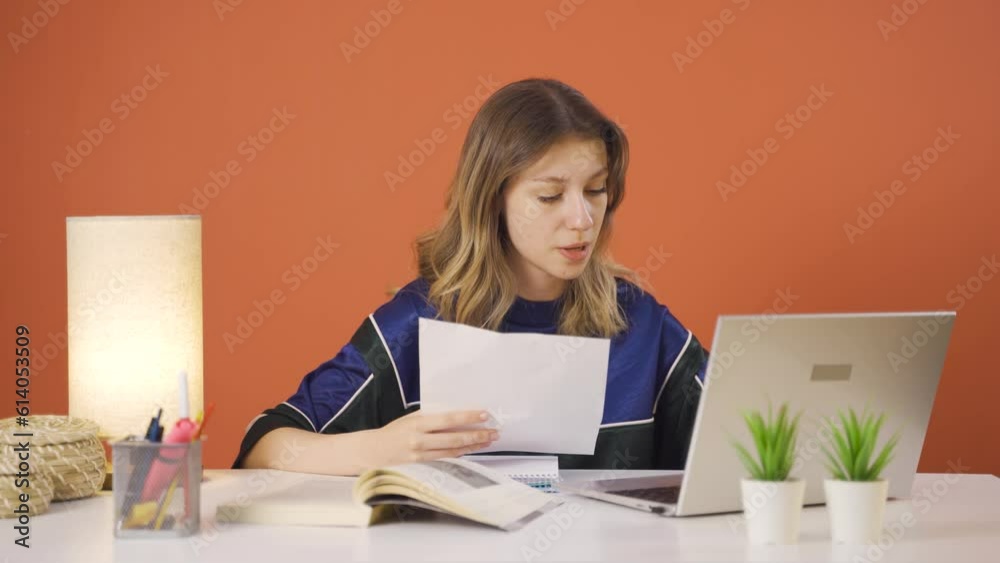 The young woman looking at the documents is thoughtful. The young woman looking at the documents is thoughtful.
