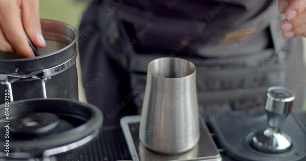 Coffee beans are weighed before grinding to get just the right amount of flavor.Male hands weighing coffee beans in stainless steel mug. Coffee beans are weighed before grinding to get just the right amount of flavor.Male hands weighing coffee beans in stainless steel mug.