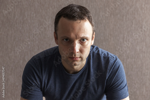 Studio portrait of a young serious Caucasian man in deep blue t-shirt © evannovostro