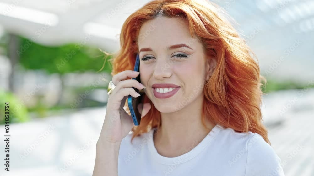 Young redhead woman talking on smartphone smiling at park Young redhead woman talking on smartphone smiling at park