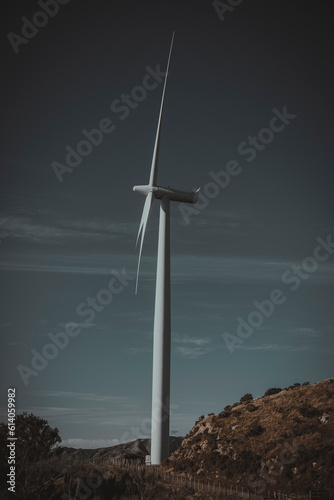 An image of a windmill or windturbine on a rugid hillline. photo