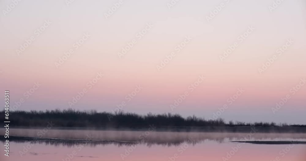 Morning mist over a lake surrounded by grass and bushes at dawn Morning mist over a lake surrounded by grass and bushes at dawn