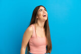 Young caucasian woman isolated on blue background laughing