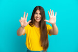 Young caucasian woman isolated on blue background counting eight with fingers