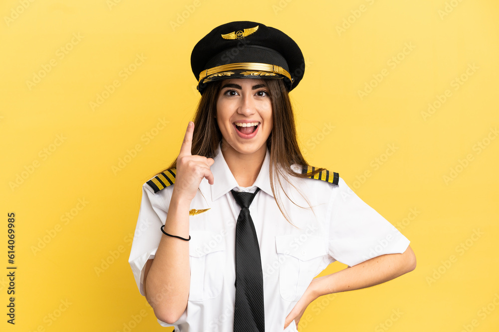 Airplane pilot isolated on yellow background thinking an idea pointing the finger up Airplane pilot isolated on yellow background thinking an idea pointing the finger up