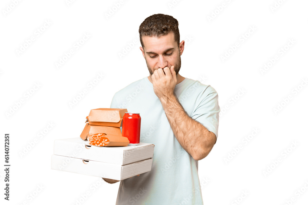 Young handsome blonde man holding pizzas and burgers over isolated background having doubts Young handsome blonde man holding pizzas and burgers over isolated background having doubts