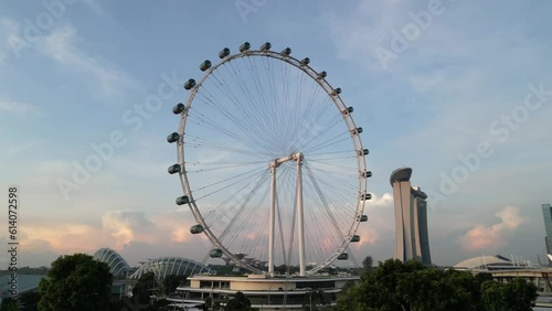 Aerial video of the Singapore city skyline featuring the Singapore Flyer observation wheel, Marina Bay Sands hotel and Gardens by the Bay at dawn