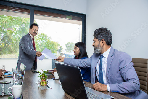 Indian businessman give report document paper to colleague, Finance and performance business statistics. Board meeting.