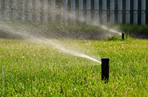 Automatic garden irrigation system watering lawn with adjustable head. Automatic equipment for irrigation and maintenance of lawns, gardening.
