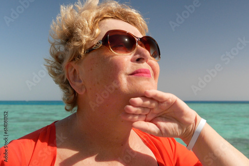 Fotografia Senior woman wiping the sweat from his forehead with a towel in sea beach, abnor